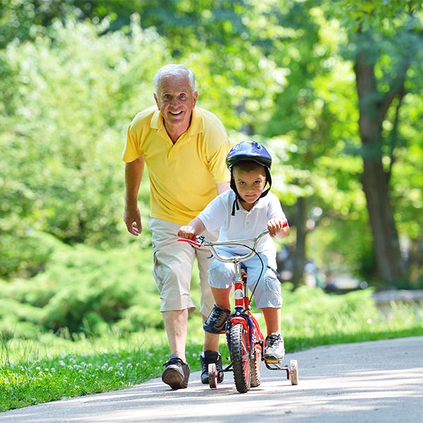 grandpa helping his grandson ride his bike in the park reasonable rate of return in retirement