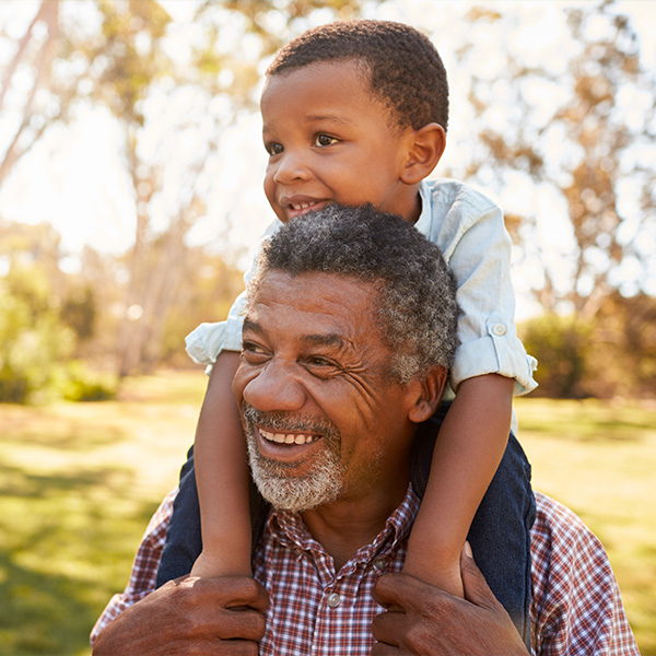grandpa with his young grandson on his shoulders outside reasonable rate of return in retirement